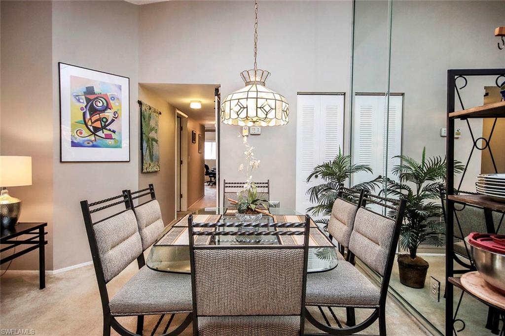 Dining area featuring carpet floors and a high ceiling