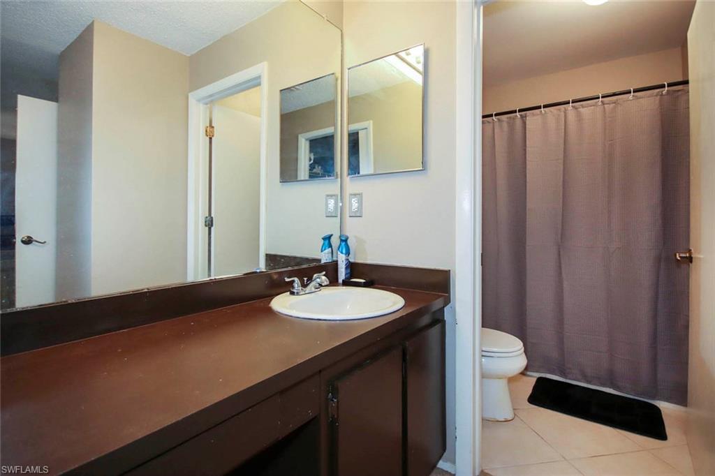 Bathroom featuring vanity, tile patterned flooring, and toilet
