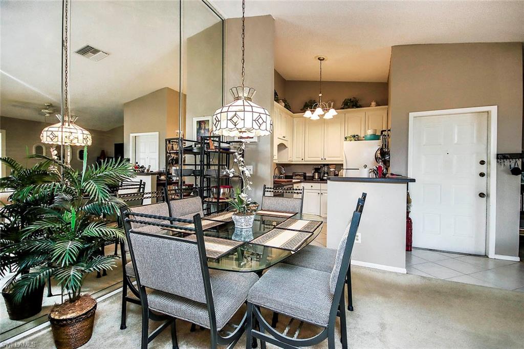 Tiled dining space with high vaulted ceiling and a chandelier