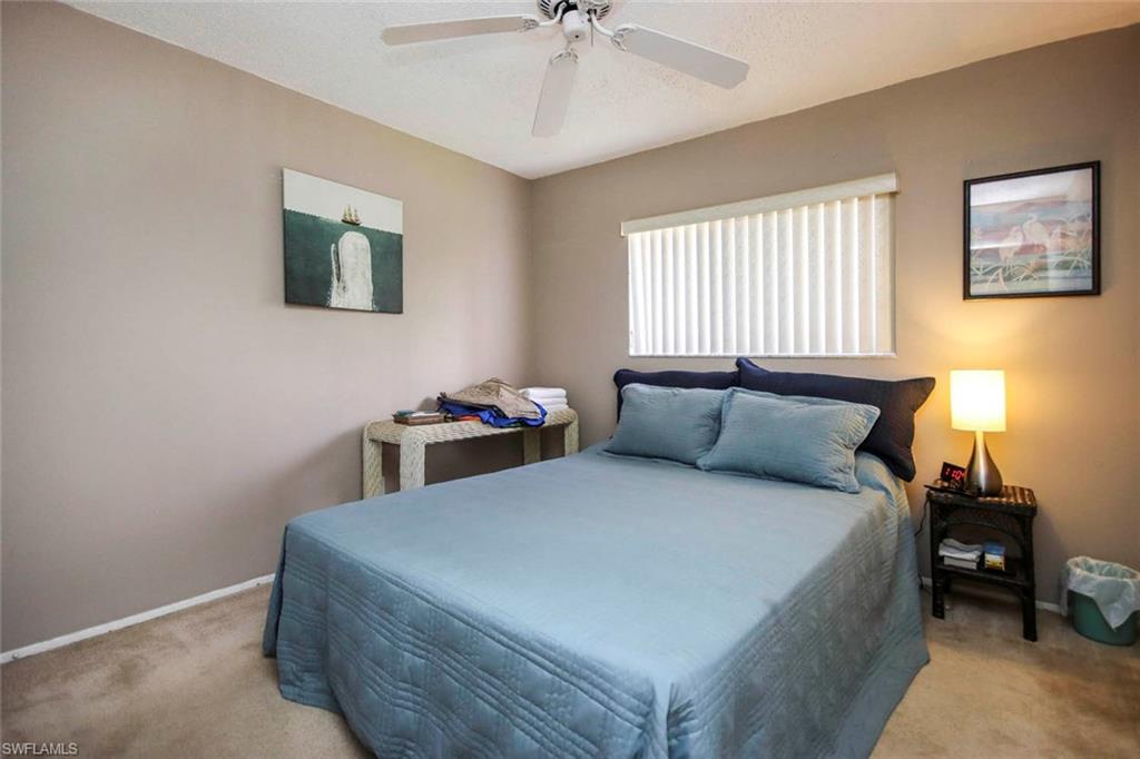 Bedroom with ceiling fan and light colored carpet