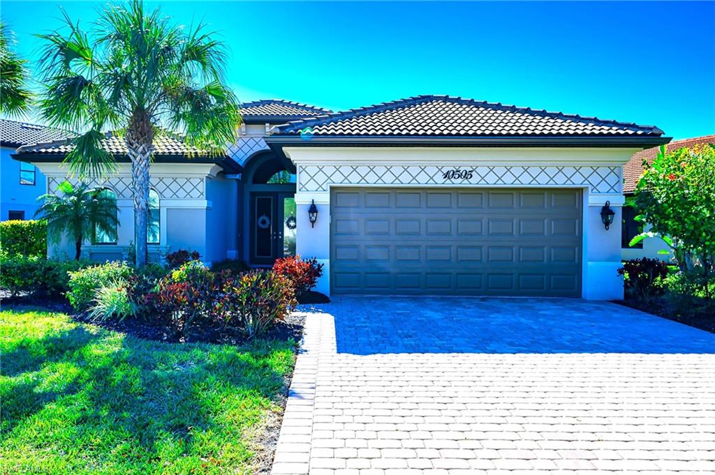 Ranch-style house with decorative driveway, a garage, and stucco siding