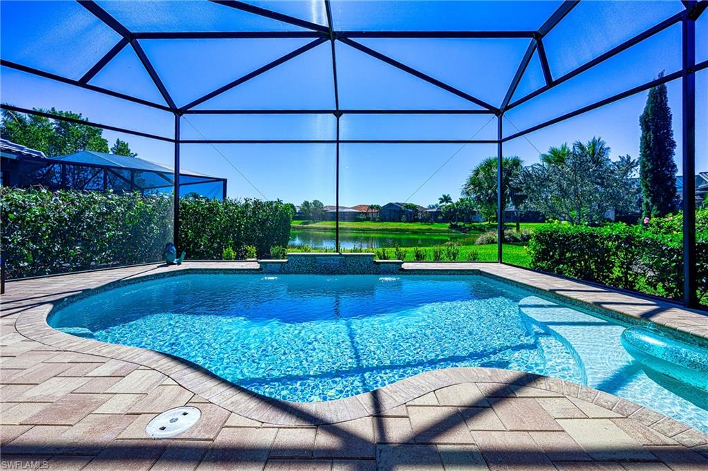 Swimming pool featuring a water view, glass enclosure, and a sunroom