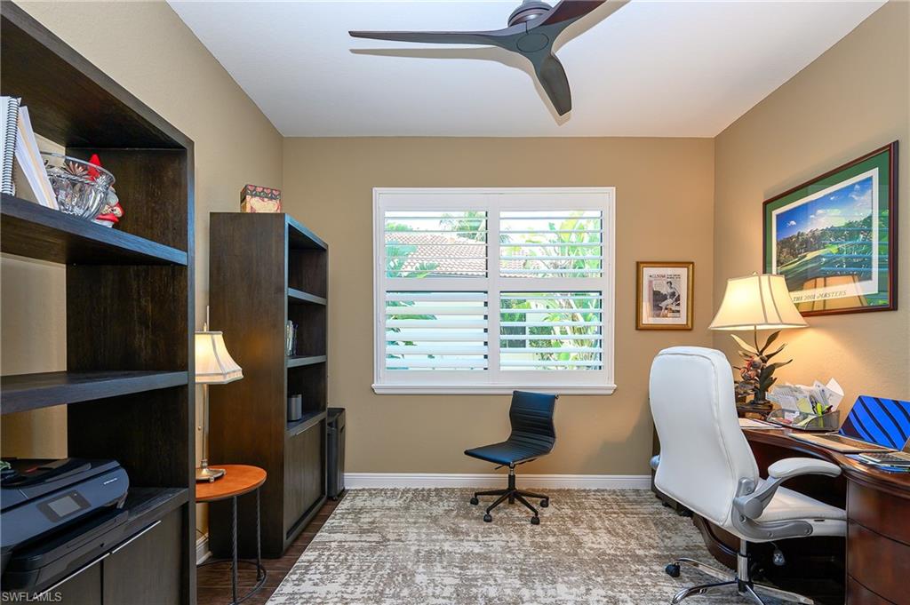 Office area with a ceiling fan and baseboards