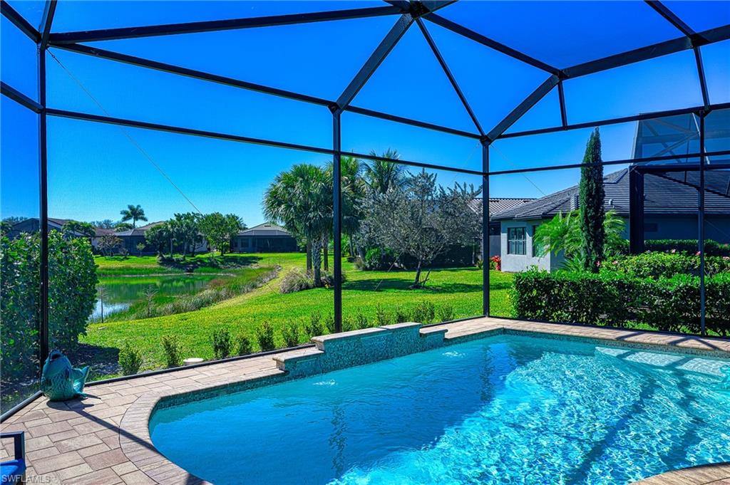 Swimming pool with a lanai, a sunroom, and a yard