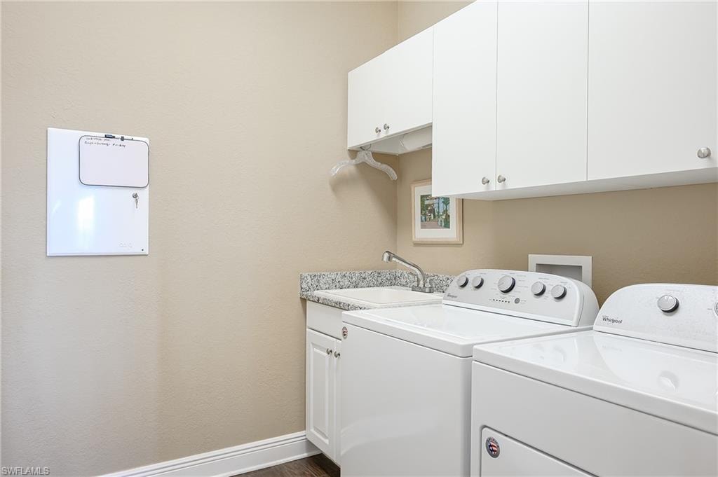 Laundry area with cabinets, laundry tub and washer/dryer