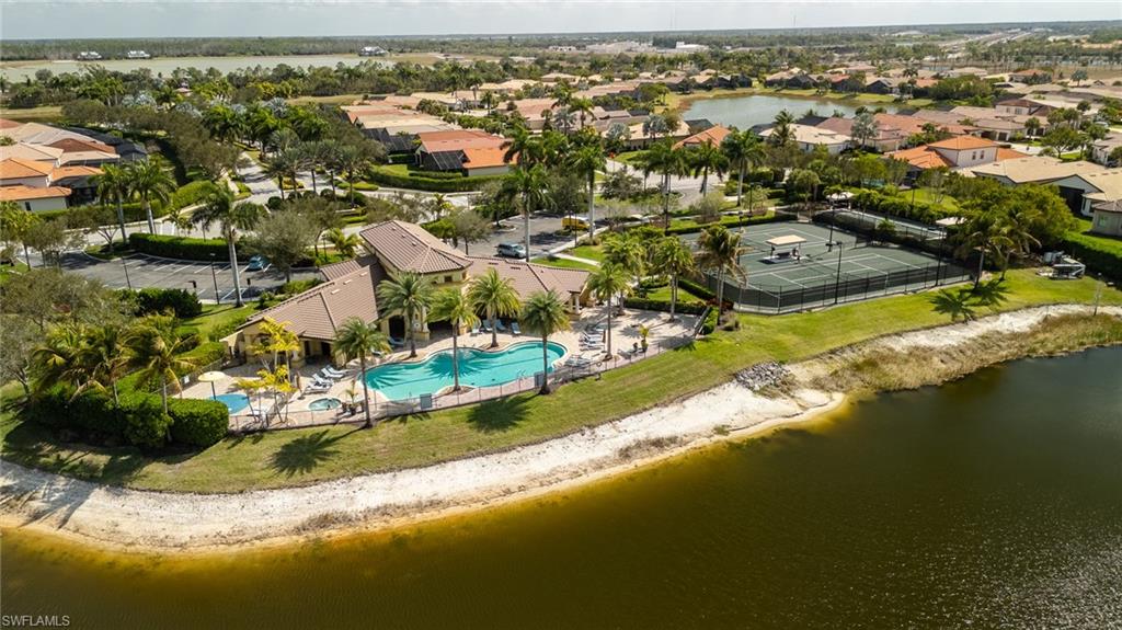 Aerial perspective of suburban area with a nearby body of water and a pool