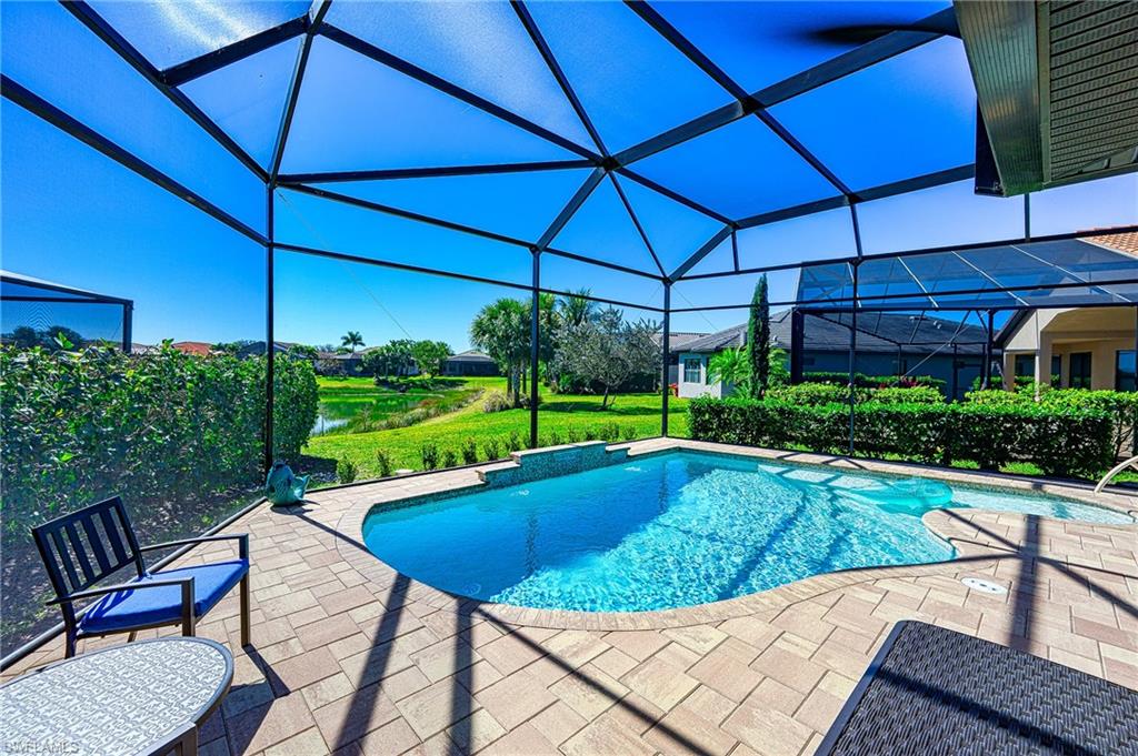 Outdoor pool with a sunroom, a lanai, a patio area, a water view, and a yard