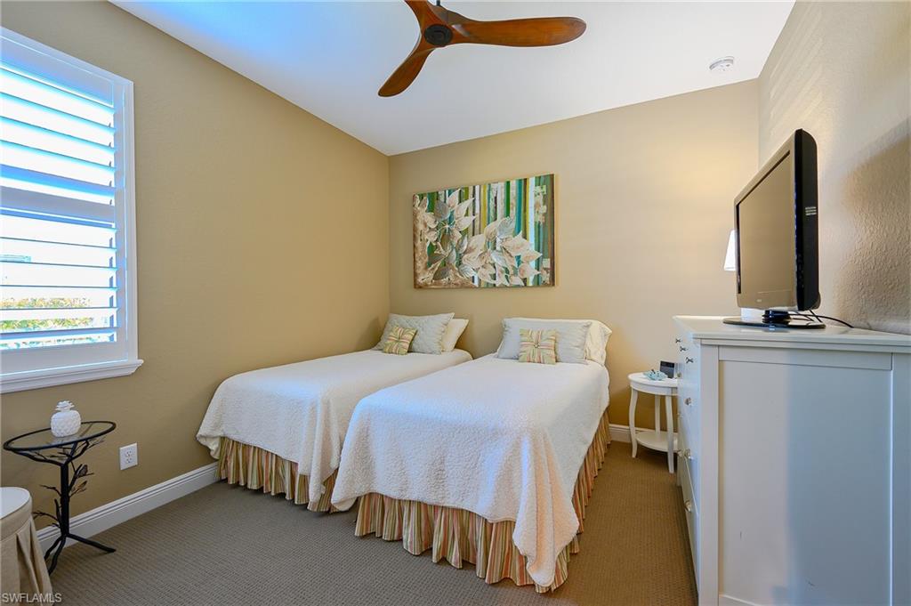 Carpeted bedroom featuring baseboards and ceiling fan