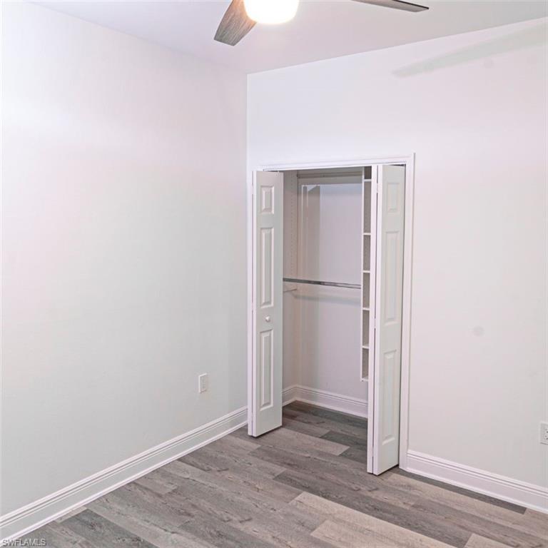 Unfurnished bedroom with a closet, light wood-style floors, and a ceiling fan