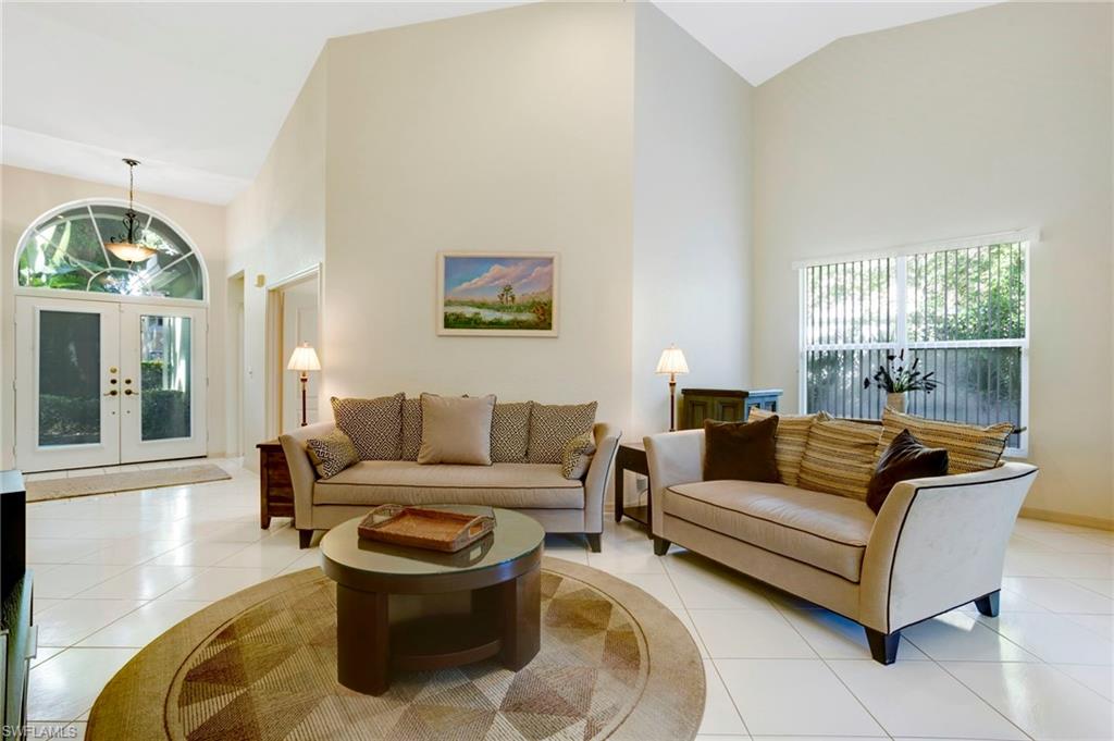 Living area featuring high vaulted ceiling, tile floors, lots of natural light