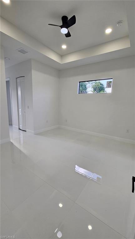 Unfurnished room with recessed lighting, a raised ceiling, and a ceiling fan