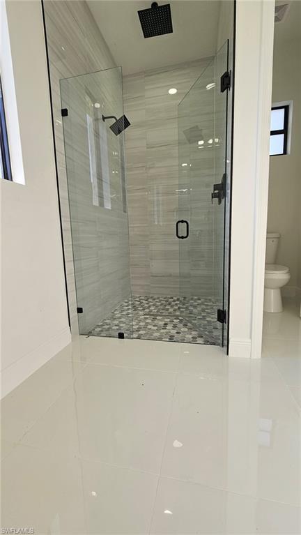 Bathroom with a stall shower and tile patterned floors