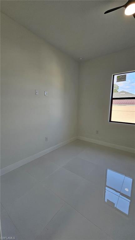 Spare room with baseboards and a ceiling fan