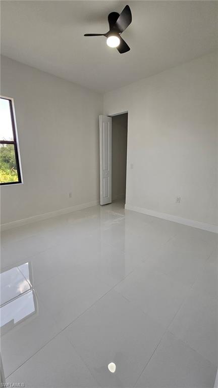 Unfurnished room featuring ceiling fan and light tile patterned flooring