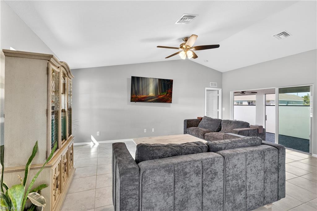 Living area featuring a ceiling fan and light tile patterned floors