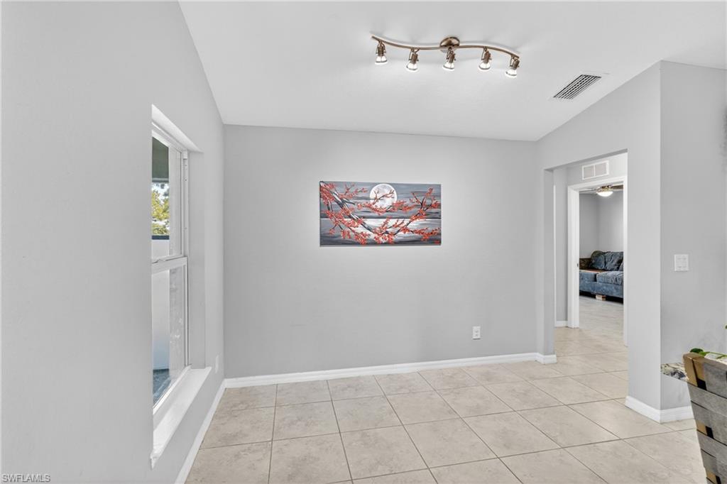 Unfurnished room featuring lofted ceiling and light tile patterned floors