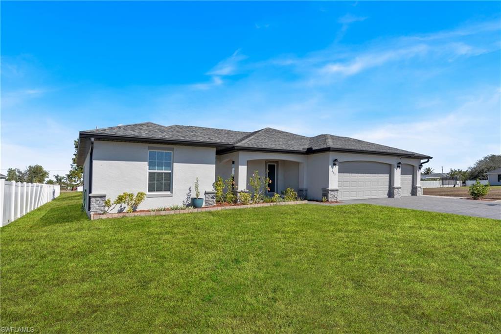 Prairie-style home featuring stucco siding, a garage, driveway, and roof with shingles