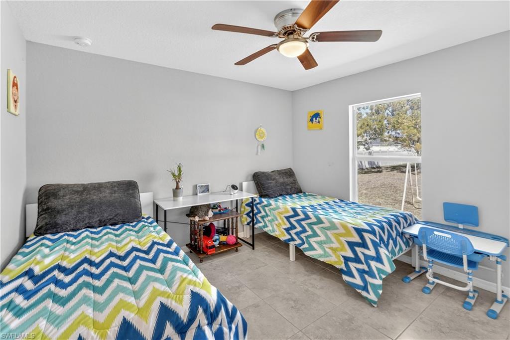 Bedroom with ceiling fan and light tile patterned floors