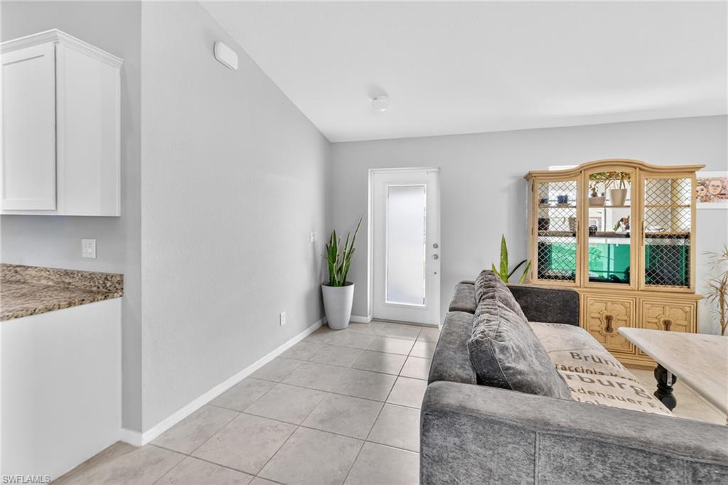 Living room featuring lofted ceiling and light tile patterned floors