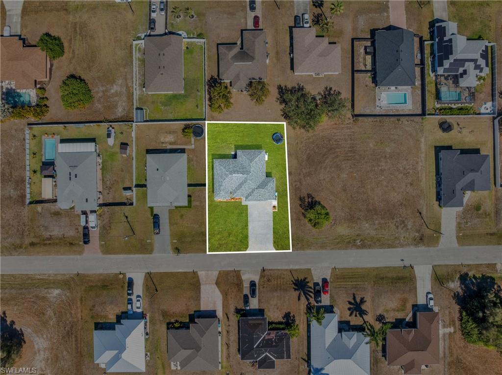 Aerial view of property and surrounding area featuring nearby suburban area