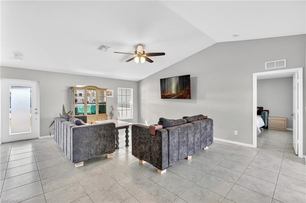 Living area with a ceiling fan and light tile patterned floors