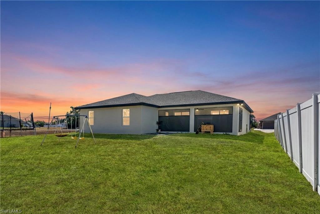 Rear view of house featuring a fenced backyard and stucco siding