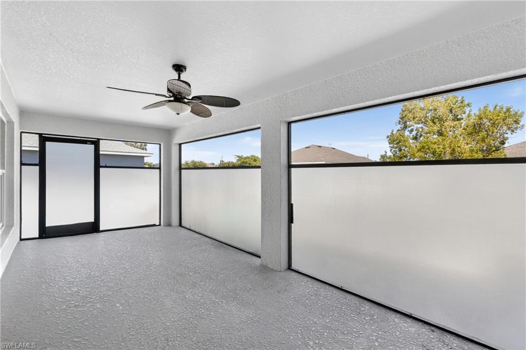 Unfurnished sunroom featuring a ceiling fan