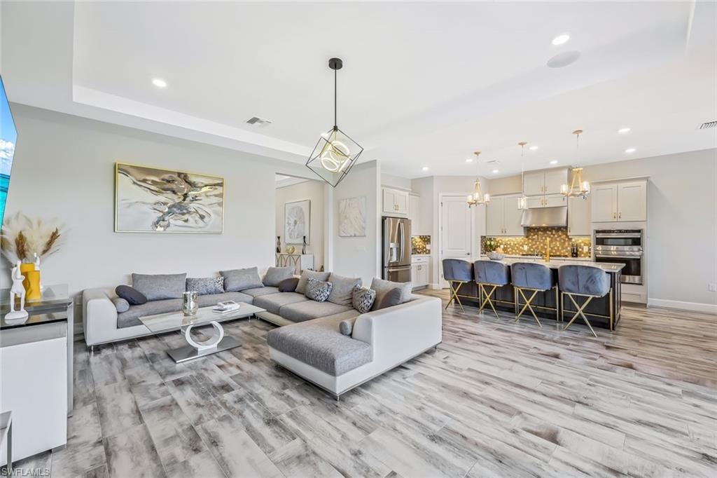 Living room with a chandelier, recessed lighting, and light wood-style floors