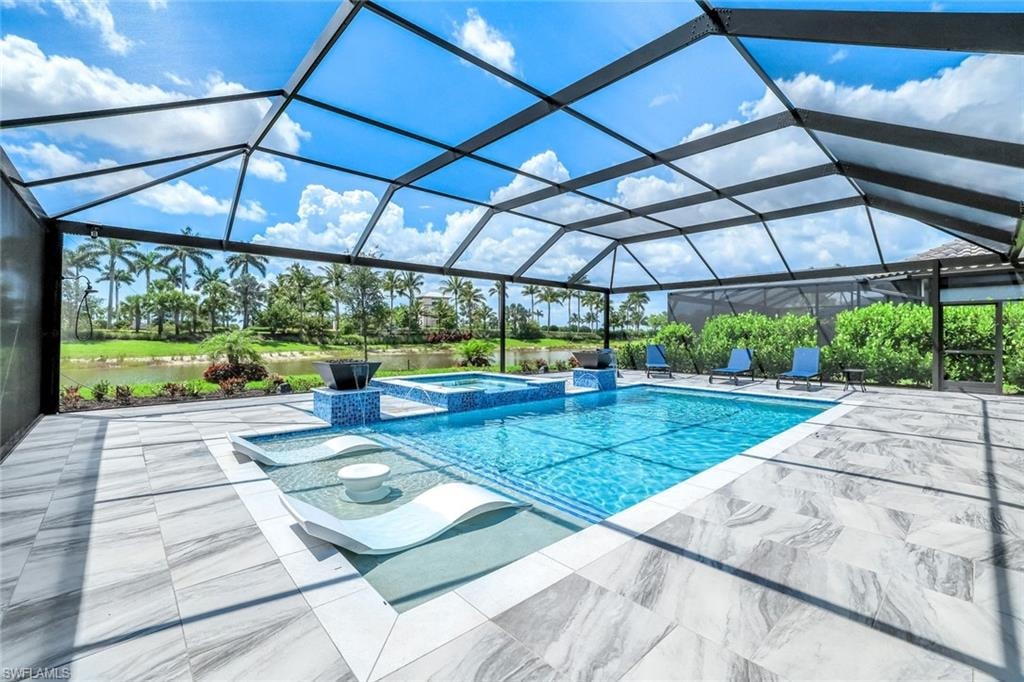 View of swimming pool featuring a patio area, a pool with connected hot tub, and a lanai