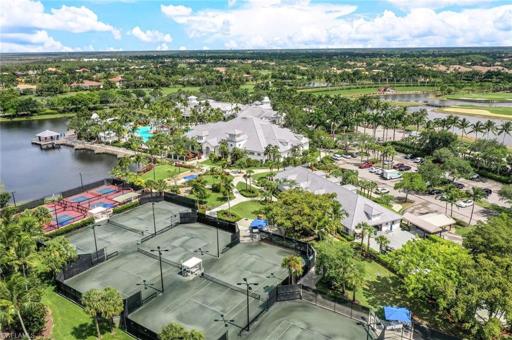 Aerial view of residential area featuring a nearby body of water and a tree filled landscape