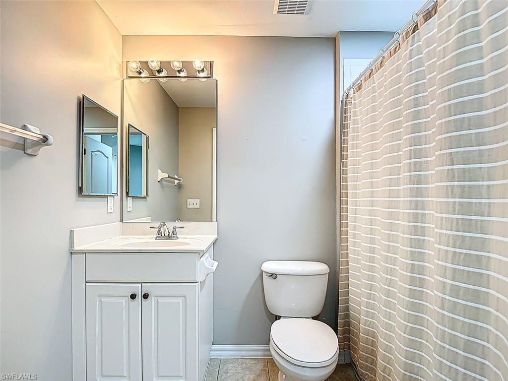 Full bath featuring vanity, a shower with curtain, and light tile patterned floors