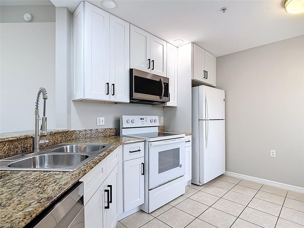 Kitchen featuring stainless steel appliances, white cabinets, and light tile patterned floors