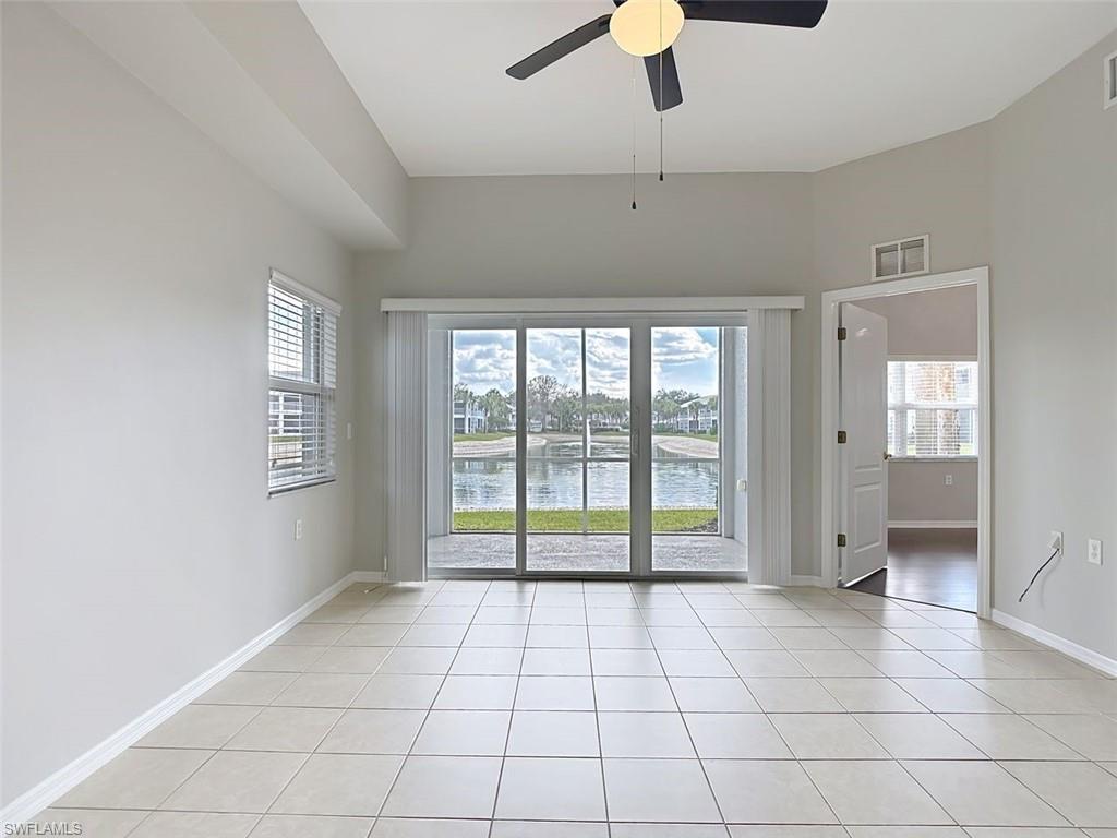 Unfurnished room with a ceiling fan, a water view, and light tile patterned floors
