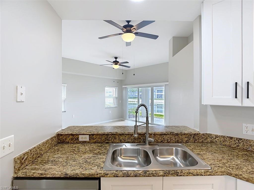 Kitchen featuring white cabinets, ceiling fan, and open floor plan