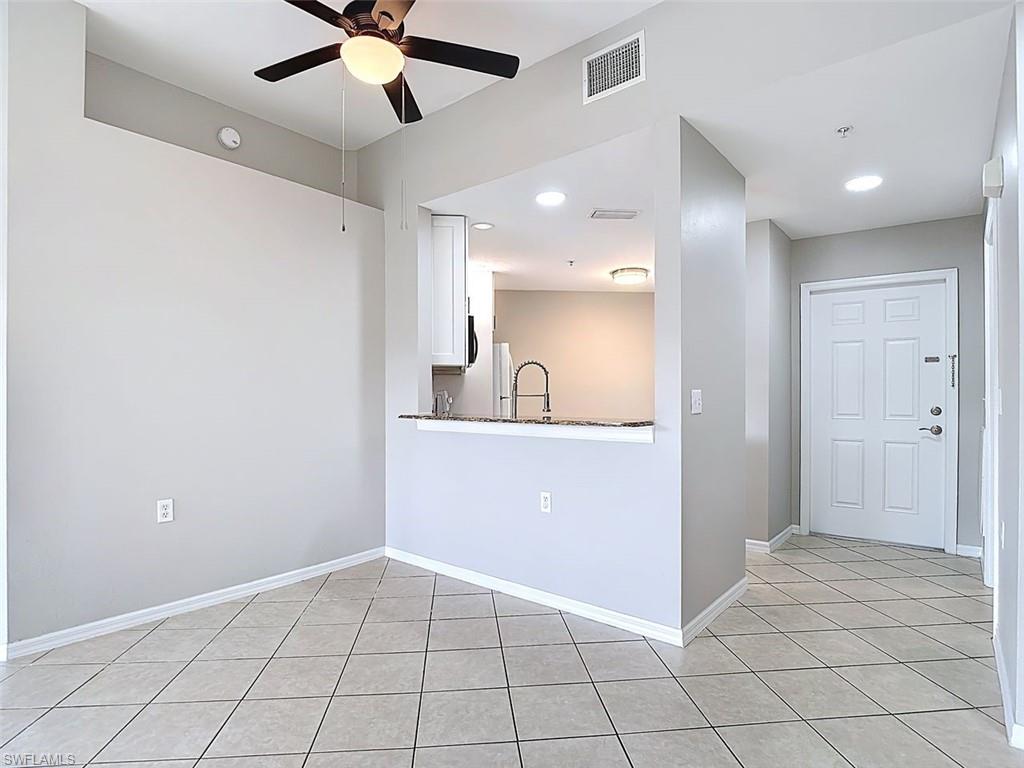 Kitchen featuring light tile patterned floors, white cabinets, recessed lighting, ceiling fan, and a peninsula
