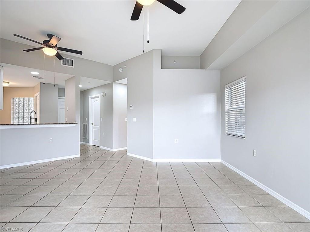 Unfurnished living room with ceiling fan and light tile patterned flooring
