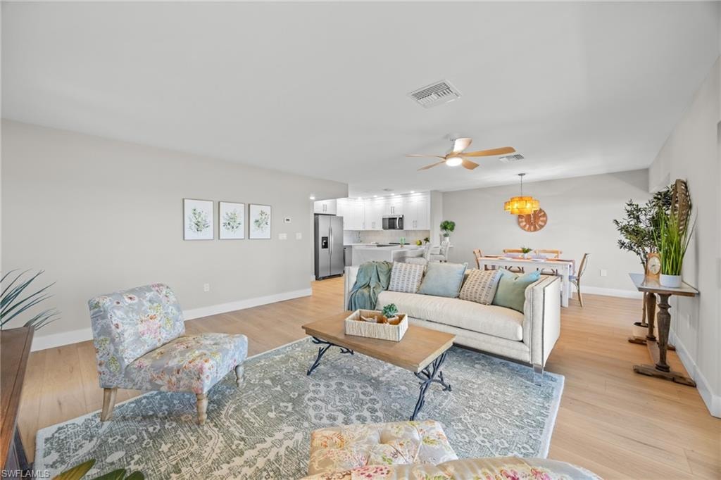 Living room with light wood finished floors and a ceiling fan