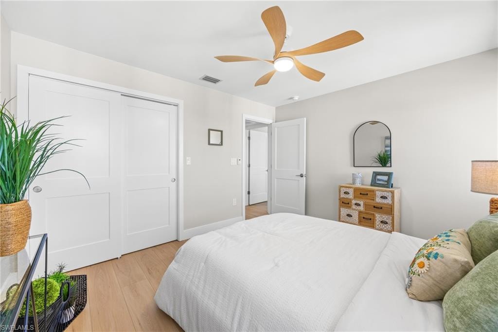 Bedroom with light wood finished floors, a closet, and a ceiling fan