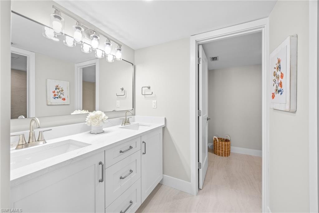 Bathroom with double vanity and baseboards