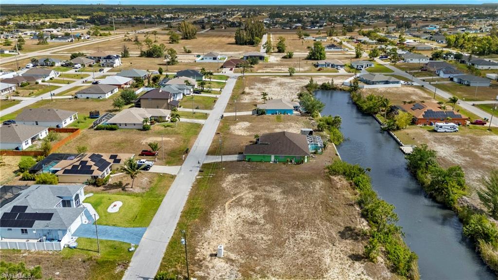 Aerial view of property and surrounding area with a large body of water and nearby suburban area