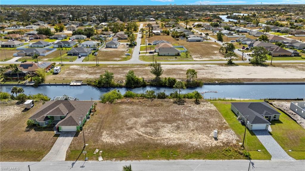 Aerial perspective of suburban area featuring a nearby body of water