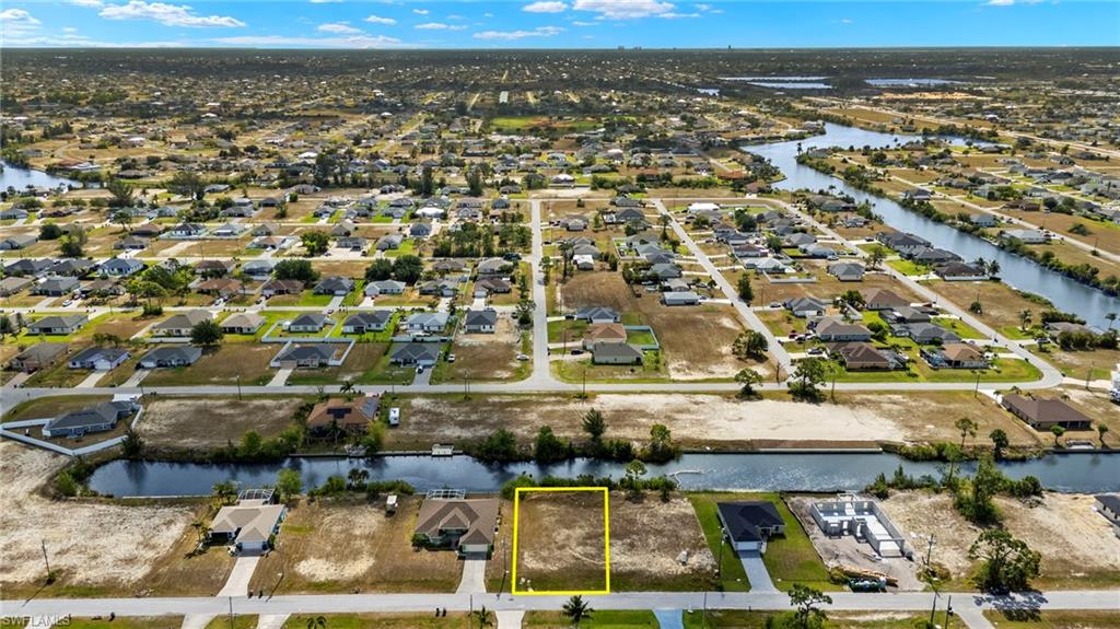 Aerial perspective of suburban area with a large body of water and property parcel outlined