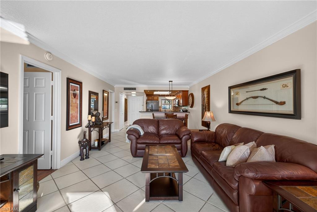 Living area featuring ornamental molding and light tile patterned floors