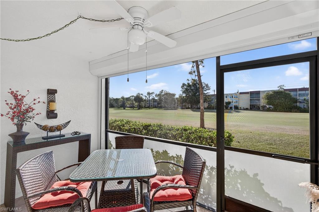 Sunroom with a ceiling fan, outdoor dining space, and view of golf course