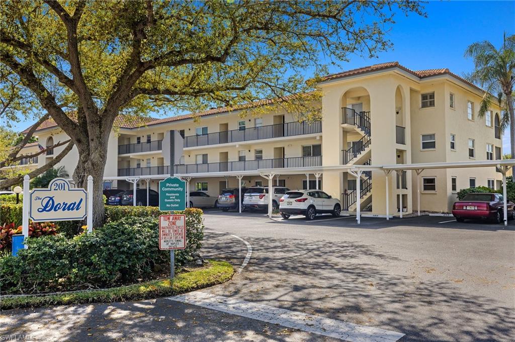 View of apartment building / complex with covered parking