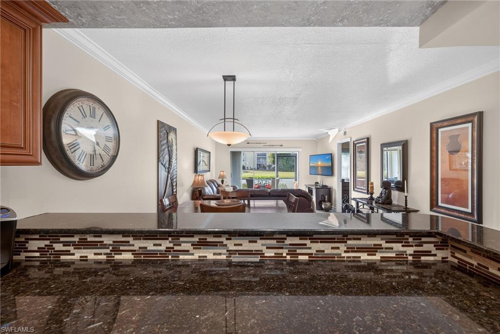Dining space with a textured ceiling and ornamental molding
