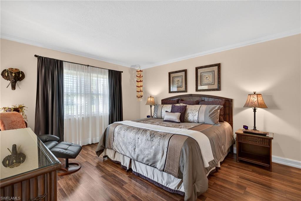 Bedroom featuring wood finished floors and crown molding