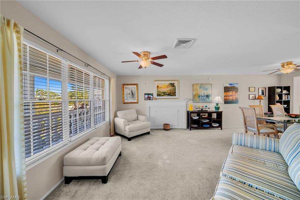 Living area featuring a ceiling fan and light colored carpet