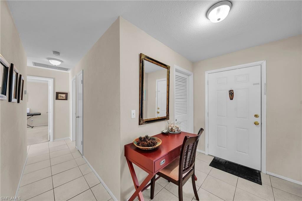 Entrance foyer featuring light tile patterned floors and baseboards