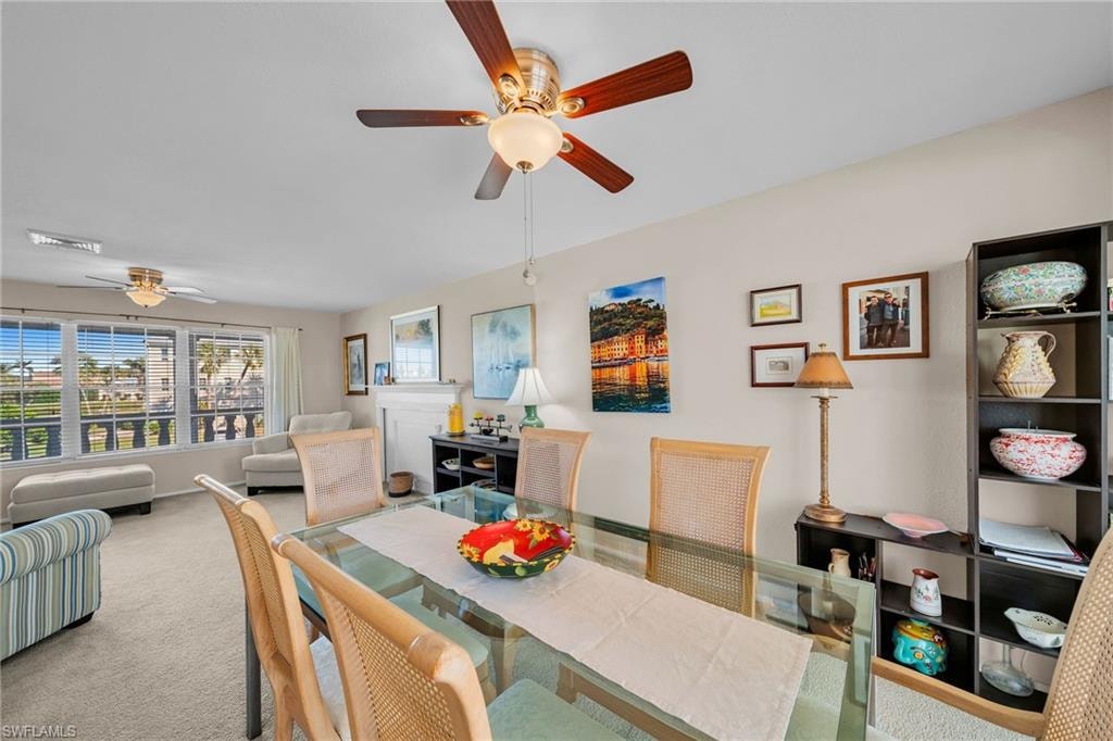 Carpeted dining space featuring a ceiling fan